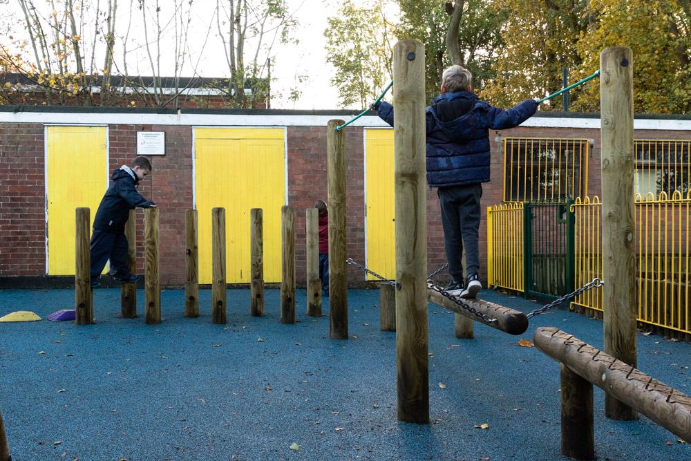 Child playing on Trim Trail Playground equipment installed in Wet Pour Rubber Surfacing